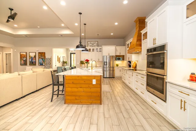 a kitchen with stainless steel appliances sink and white cabinets