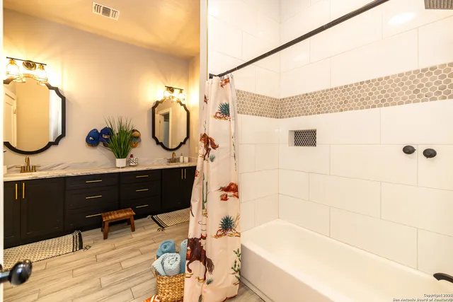 a bathroom with a double vanity sink and a mirror
