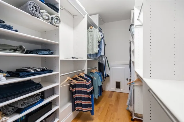 a view of walk in closet with clothes and shoes