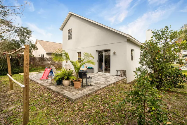 a view of a patio with table and chairs potted plants and floor to ceiling window