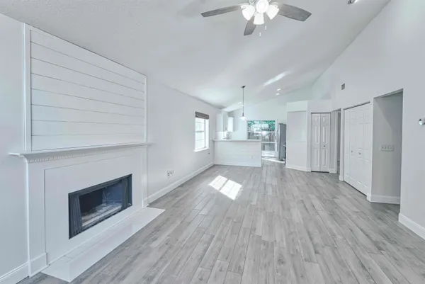 a view of empty room with wooden floor and fireplace