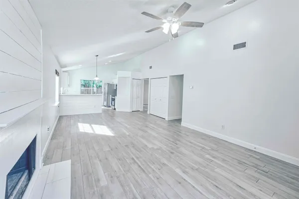 an empty room with wooden floor and windows