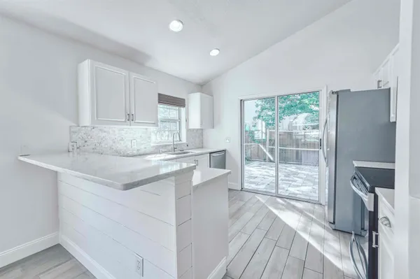 a kitchen with stainless steel appliances granite countertop a refrigerator and a sink