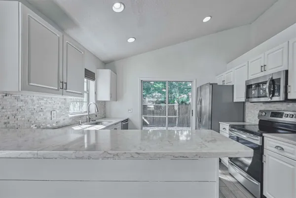 a kitchen with granite countertop a sink and a stove