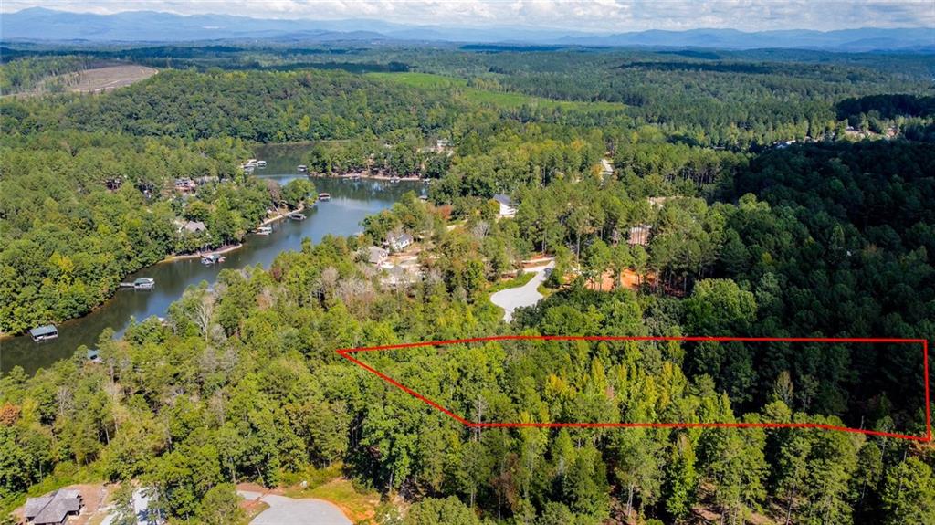 Lot 30 Harbor Point Seneca, SC 29672 - Photo 10 of 12 A verdant parcel bordered by mature trees, nestled within a scenic lake community.