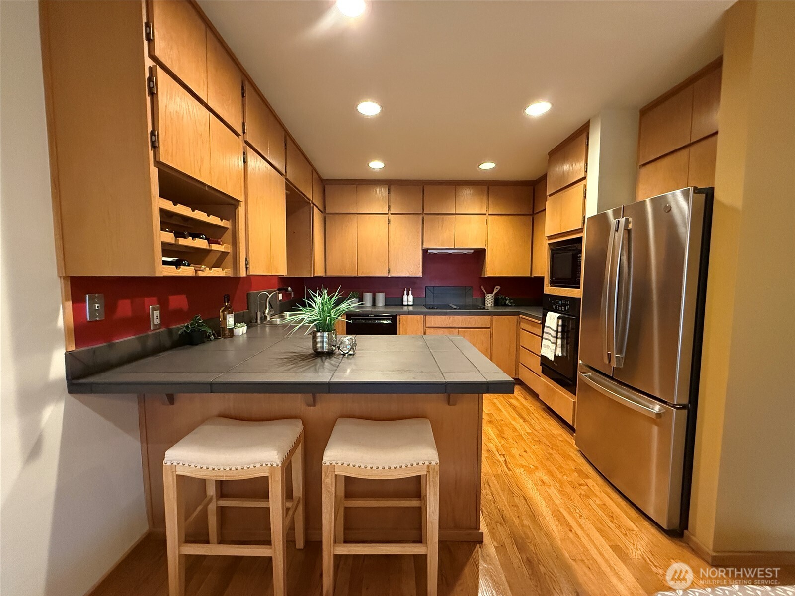 620 West Mercer Place, Unit 2B Seattle, WA 98119 - Photo 10 of 28 a kitchen with stainless steel appliances granite countertop a table chairs refrigerator and sink
