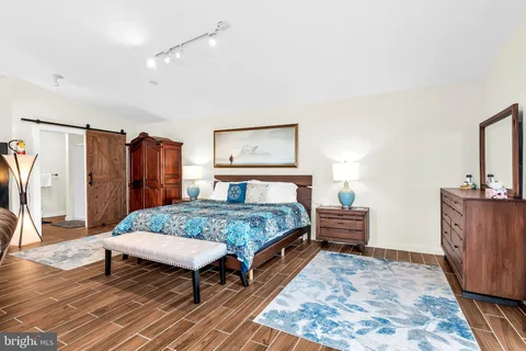 a bedroom with a bed and a painting on the wall