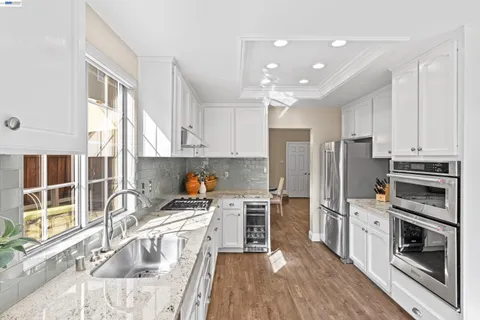 a kitchen with kitchen island granite countertop a stove a sink and a refrigerator