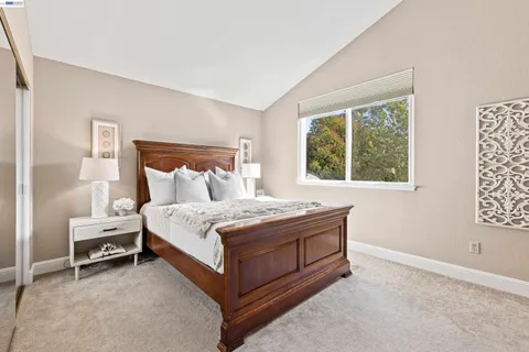 a bed sitting in a bedroom next to a window