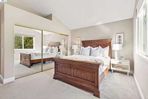 a bedroom with a bed and large windows