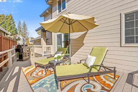 a view of a patio with chairs and table under an umbrella