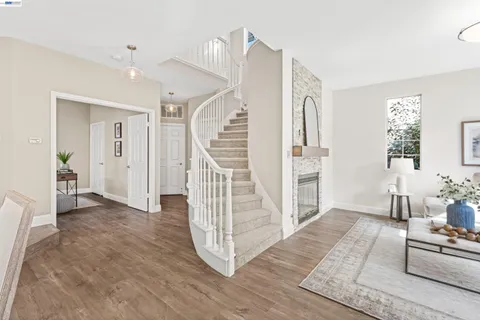 a view of a livingroom with wooden floor and stairs