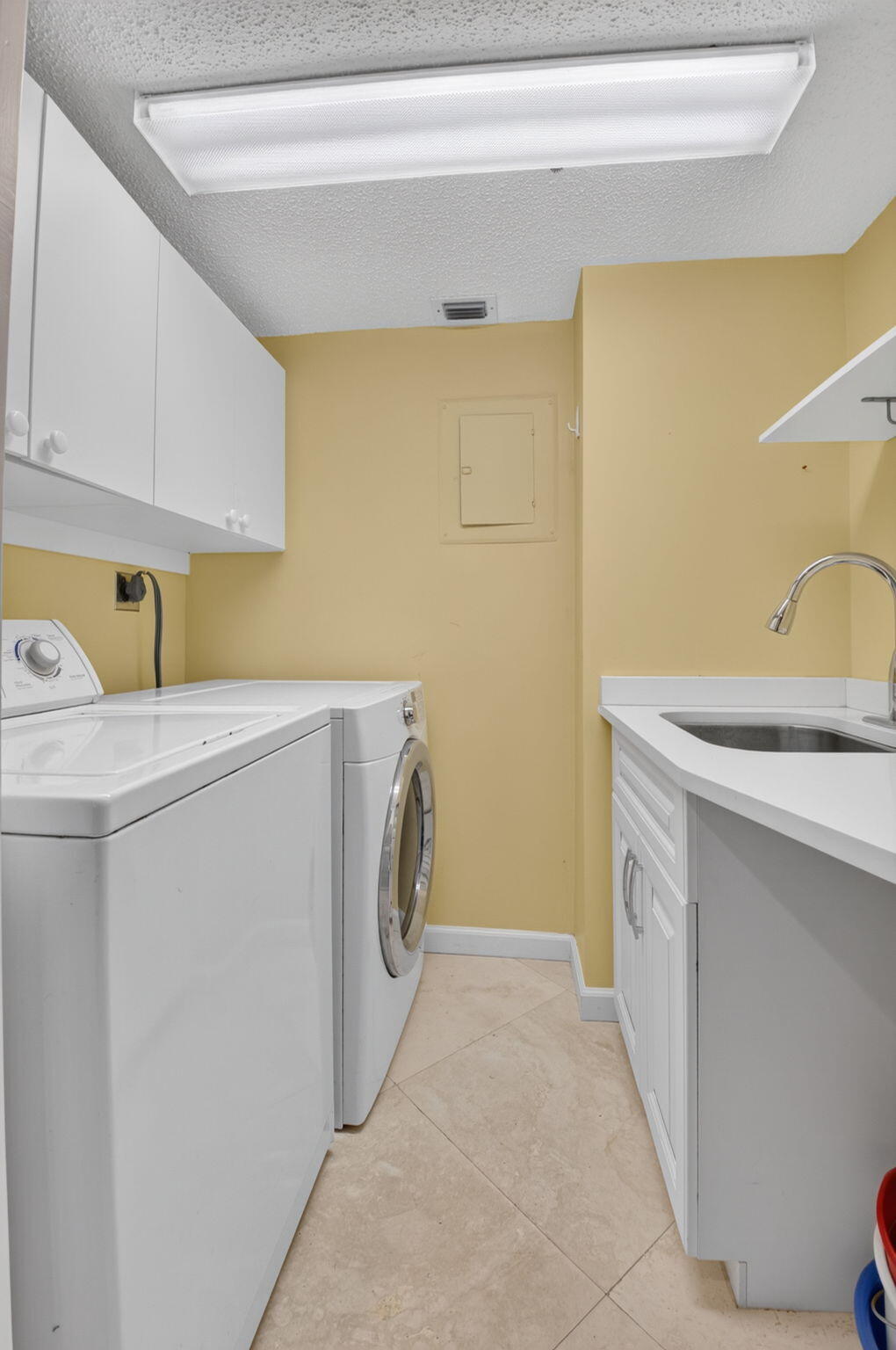 1401 South Ocean Boulevard, Unit 1060 Boca Raton, FL 33432 - Photo 15 of 46 a utility room with a sink a washer and dryer