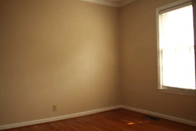 a view of a small space with wooden floor and a window