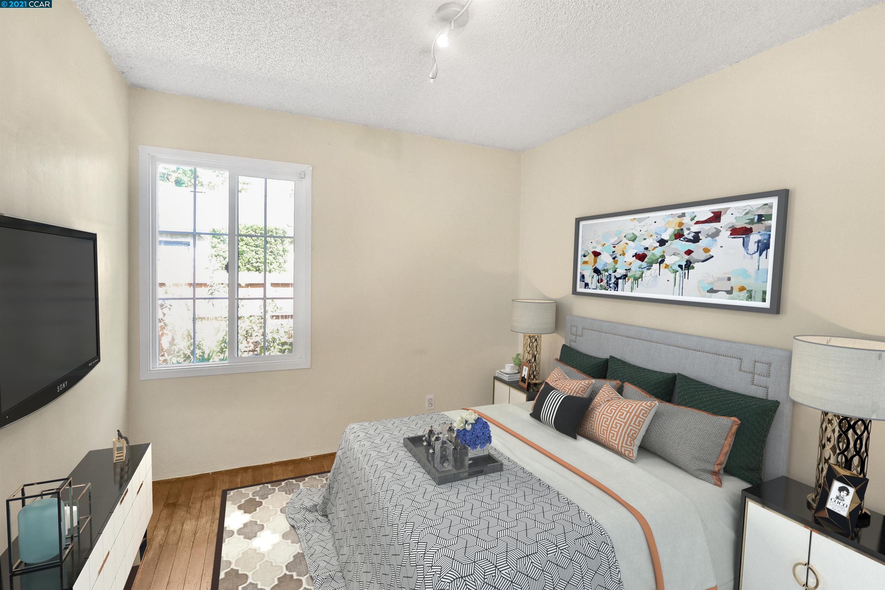 a bedroom with bed and a flat screen tv