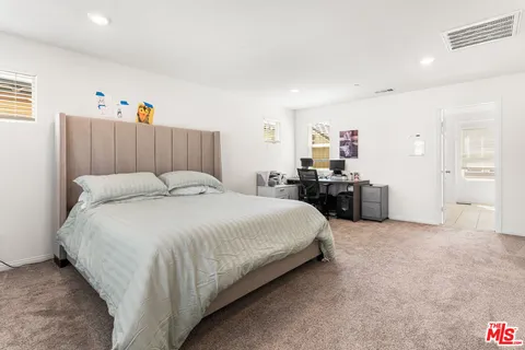 a bedroom with a bed closet and flat screen tv