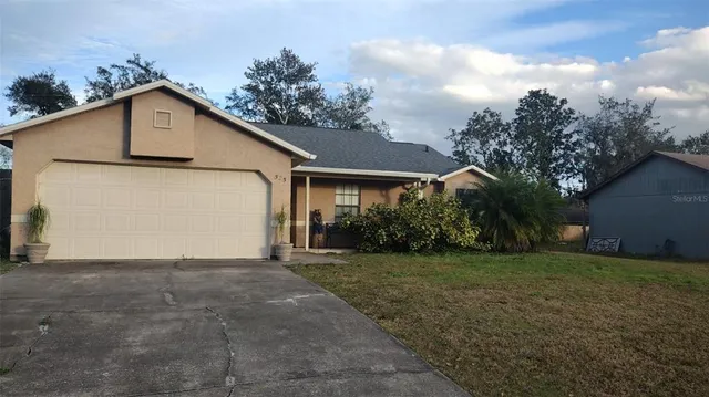 a view of a house with a yard and large tree