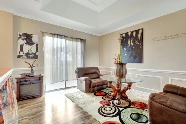 a view of an empty room with a window and hardwood floor