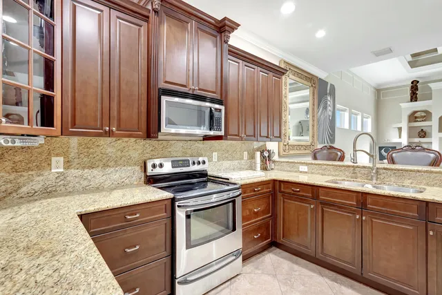 a kitchen with stainless steel appliances granite countertop a refrigerator and a sink