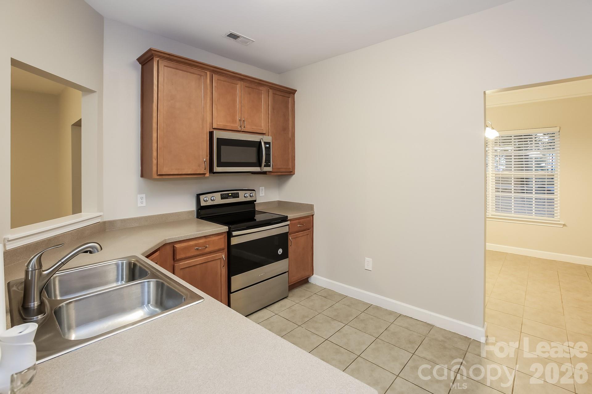 8812 Cornwall Street Locust, NC 28097 - Photo 4 of 15 a kitchen with granite countertop a stove and a microwave