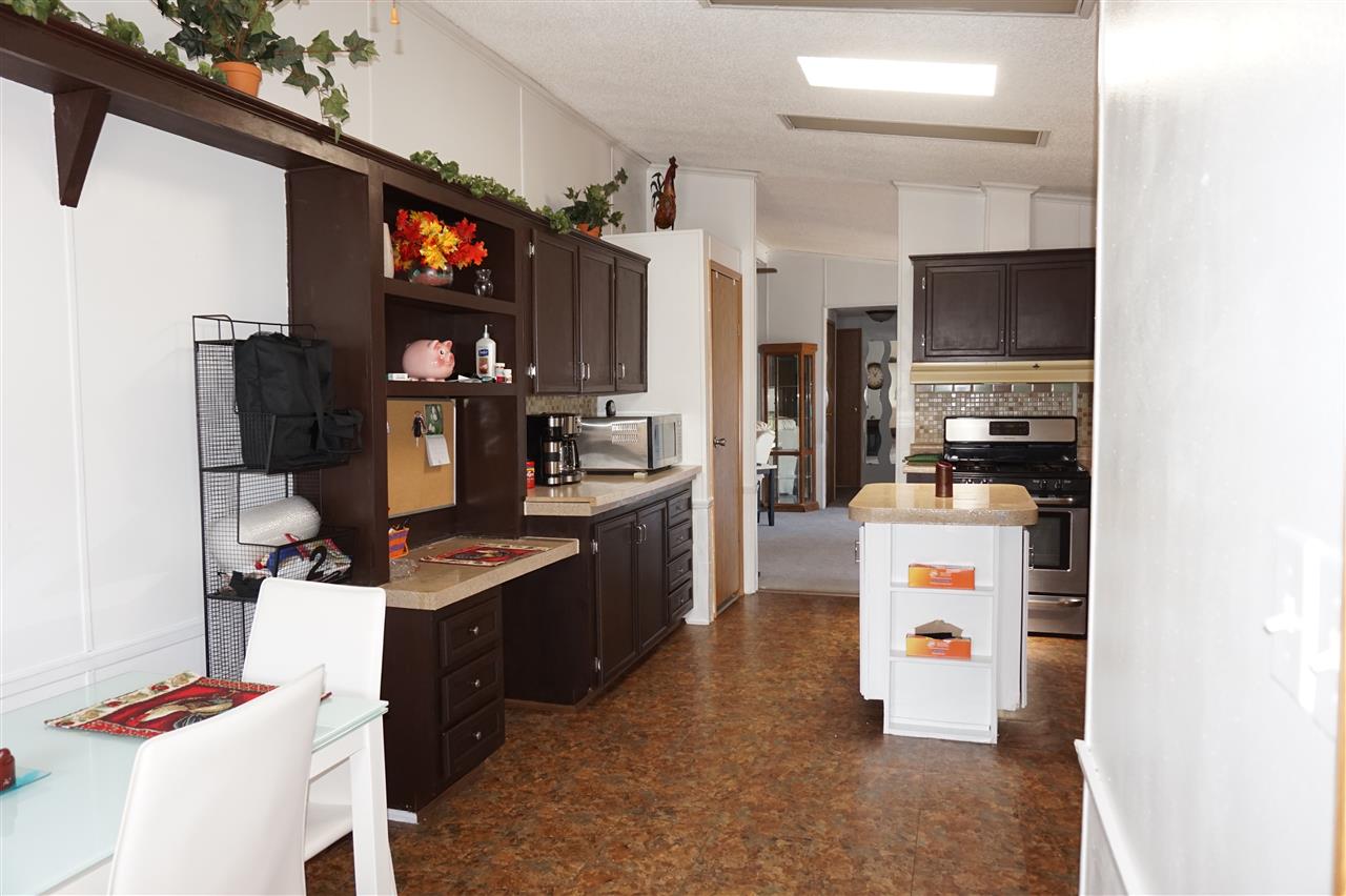 5134 Rockberry Road Loves Park, IL 61111 - Photo 8 of 24 a room with furniture a flat screen tv and kitchen view