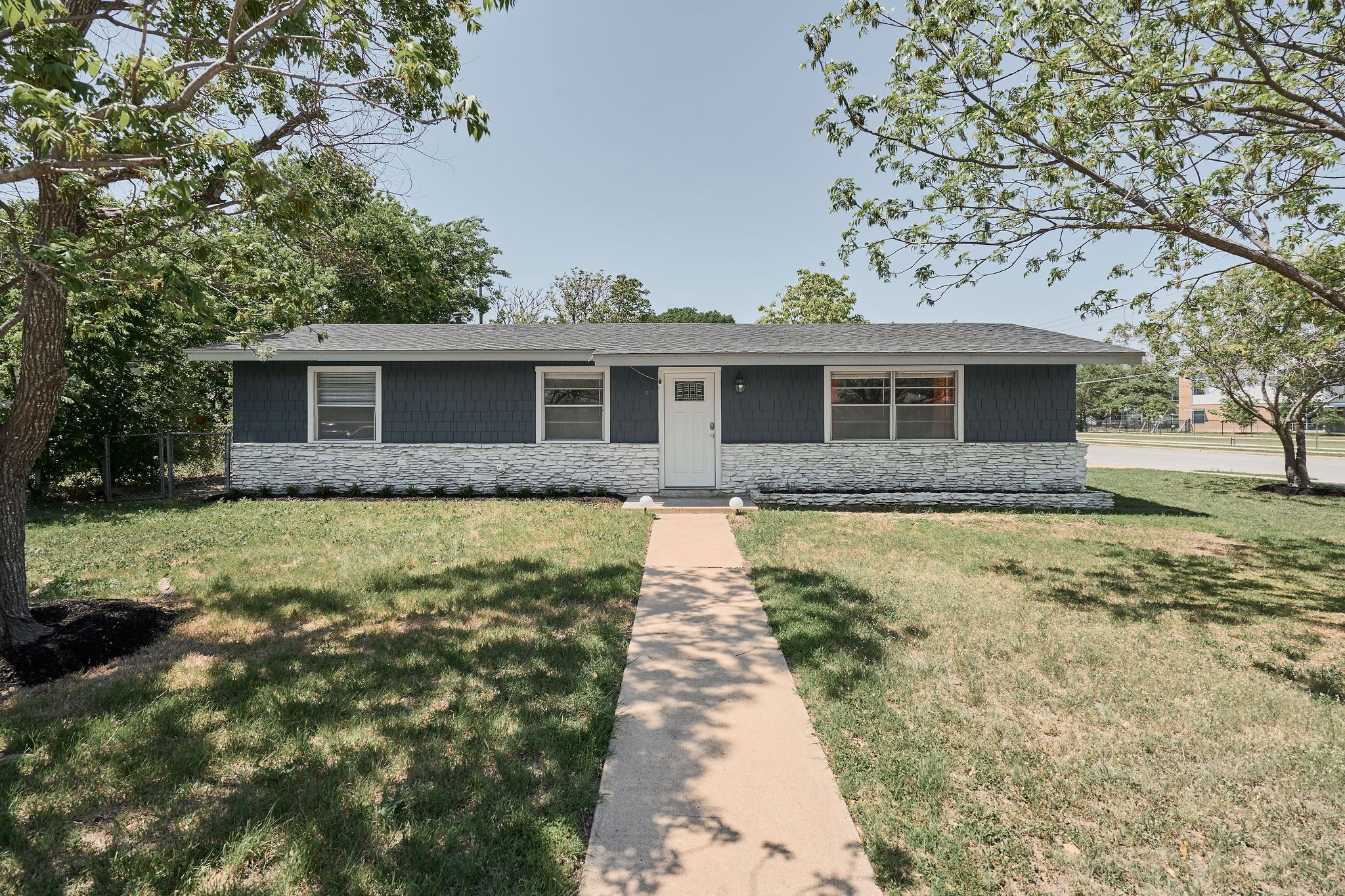 View of front of property with stone siding and a front lawn