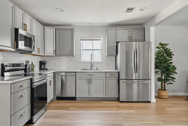 a kitchen with appliances a refrigerator and a sink