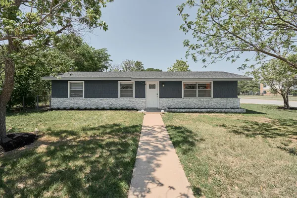 a front view of house with yard and trees around