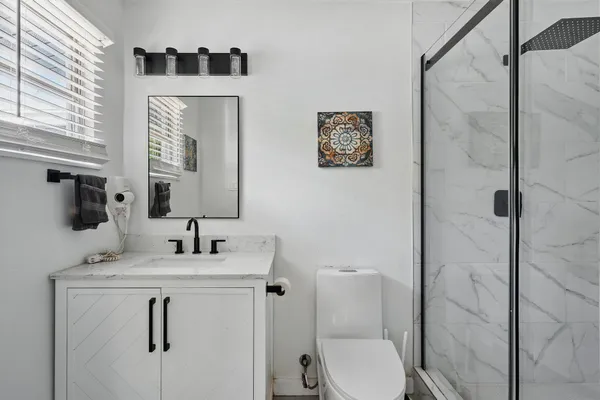 a bathroom with a toilet sink vanity and mirror