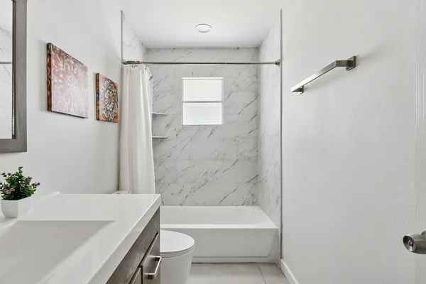a bathroom with a bathtub a toilet and a shower