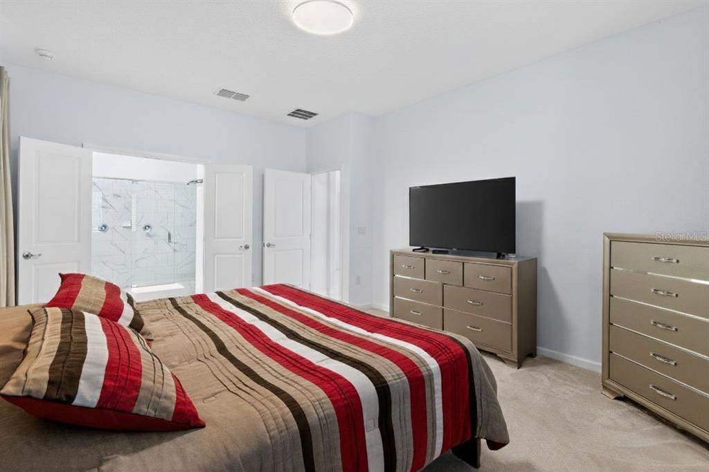4577 Cabello Loop Kissimmee, FL 34746 - Photo 15 of 37 a bedroom with a bed and a flat screen tv