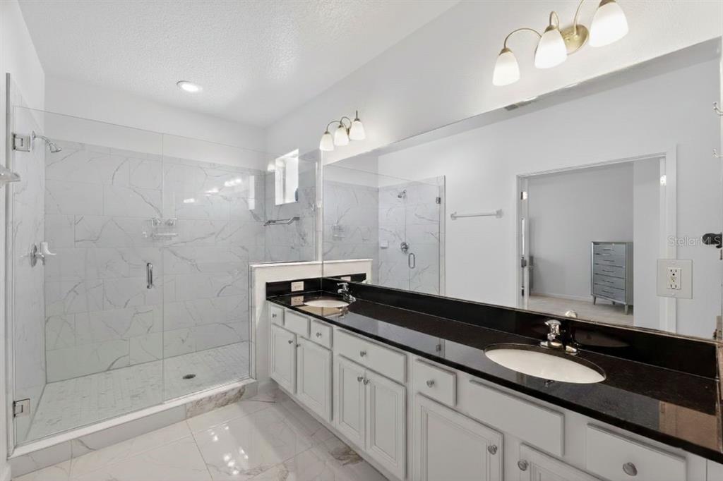 4577 Cabello Loop Kissimmee, FL 34746 - Photo 21 of 37 a bathroom with a granite countertop sink mirror and double