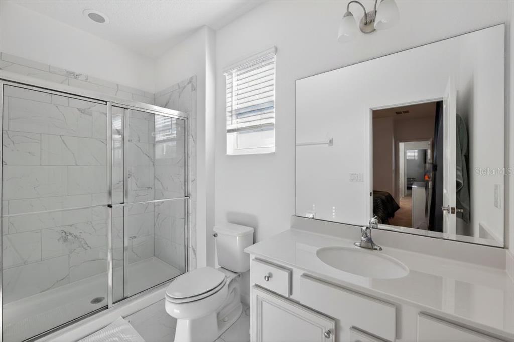 4577 Cabello Loop Kissimmee, FL 34746 - Photo 24 of 37 a bathroom with a sink toilet and shower