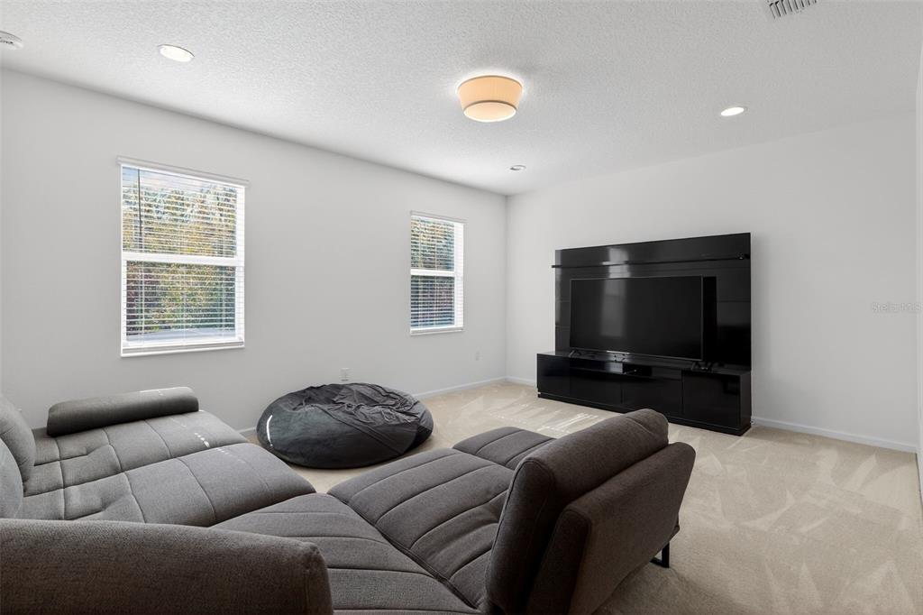 4577 Cabello Loop Kissimmee, FL 34746 - Photo 26 of 37 a living room with furniture and a flat screen tv