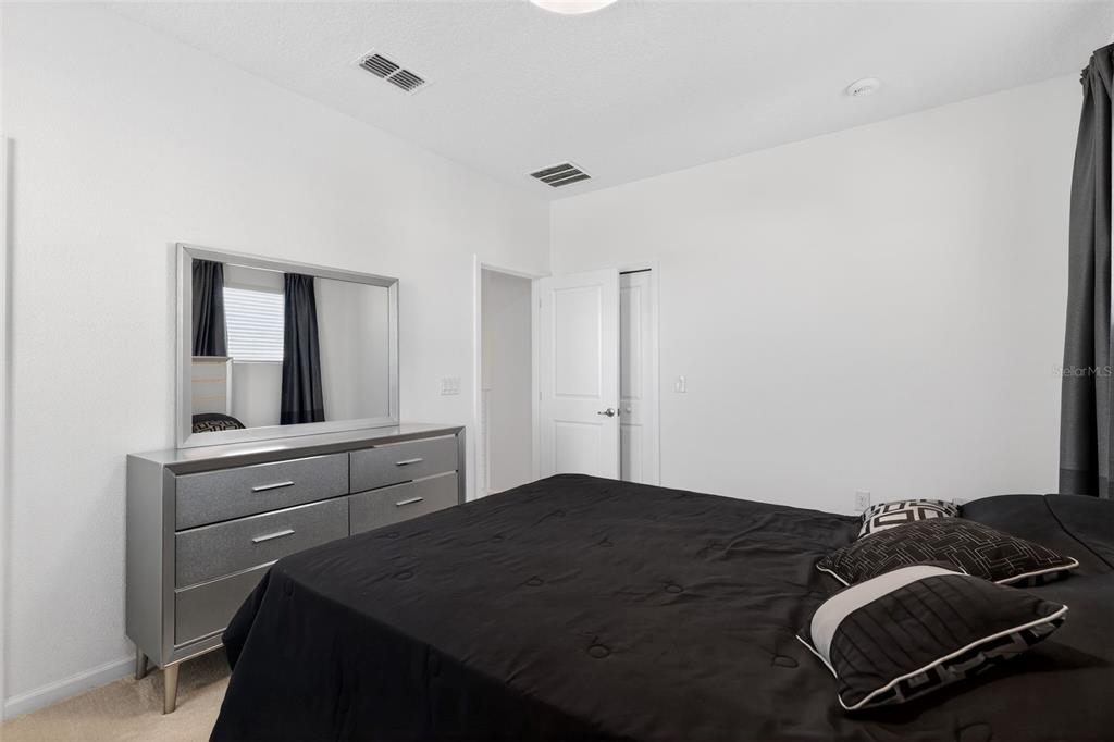 4577 Cabello Loop Kissimmee, FL 34746 - Photo 34 of 37 a bedroom with a bed and dresser