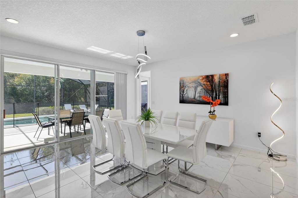 4577 Cabello Loop Kissimmee, FL 34746 - Photo 4 of 37 a view of a dining room with furniture large windows and wooden floor