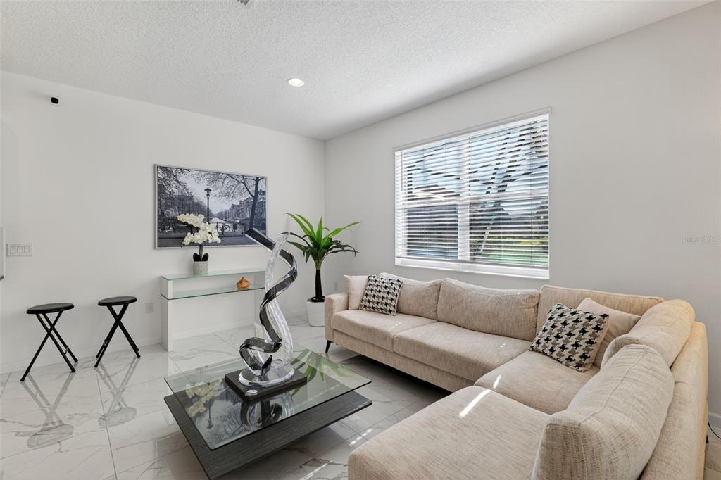4577 Cabello Loop Kissimmee, FL 34746 - Photo 8 of 37 a living room with furniture and a potted plant