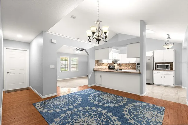 a open kitchen with stainless steel appliances granite countertop a refrigerator and a stove top oven