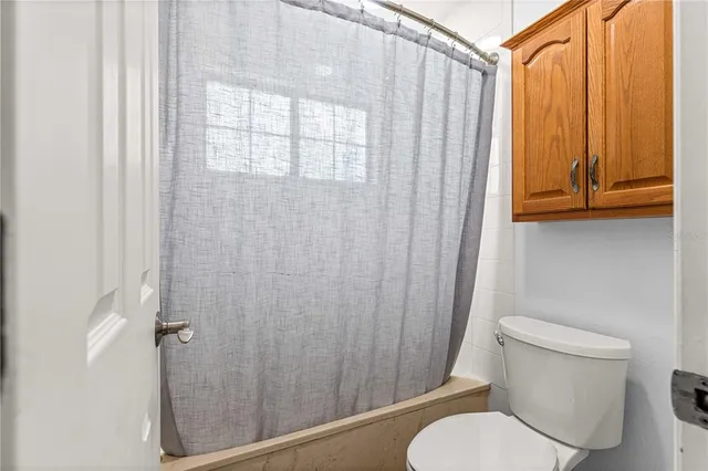 an empty room with fan and windows