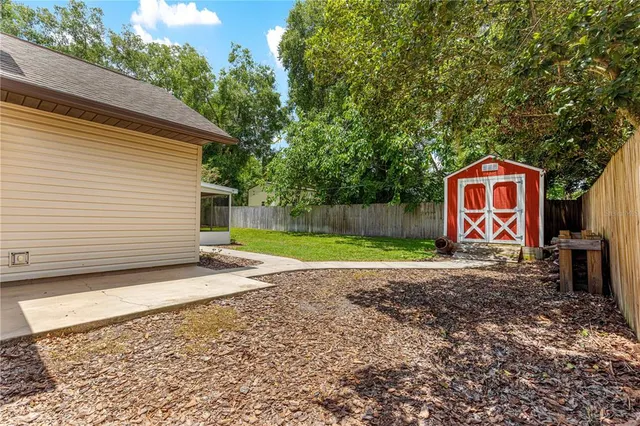a view of a house with backyard and sitting area