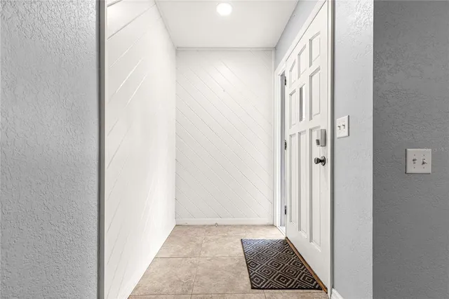 a view of a hallway with wooden floor and a bathroom