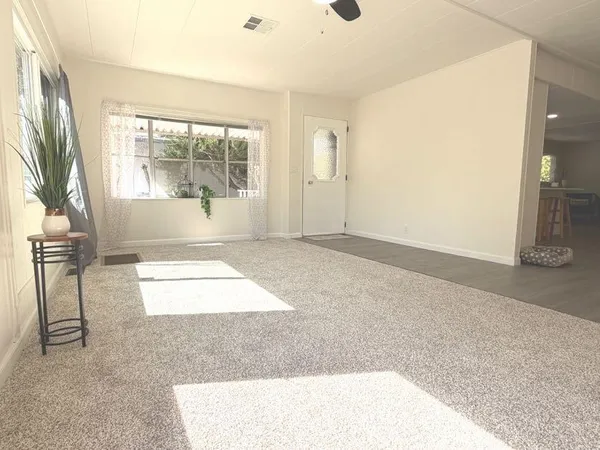an empty room with floor to ceiling windows and chandelier