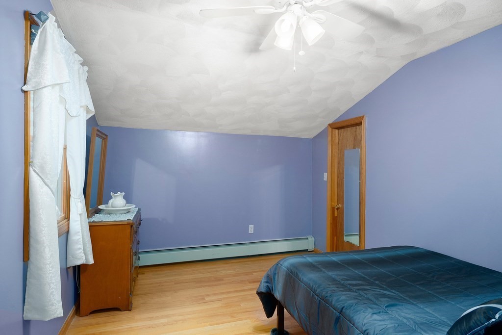 102 Orange Street Reading, MA 01867 - Photo 19 of 23 a bedroom with a bed and a potted plant