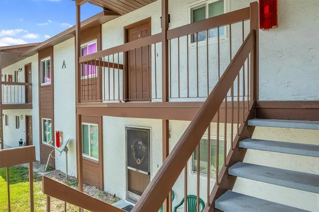 a view of staircase with lots of frames on wall and a potted plant