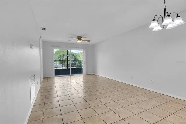 an empty room with windows and ceiling fan