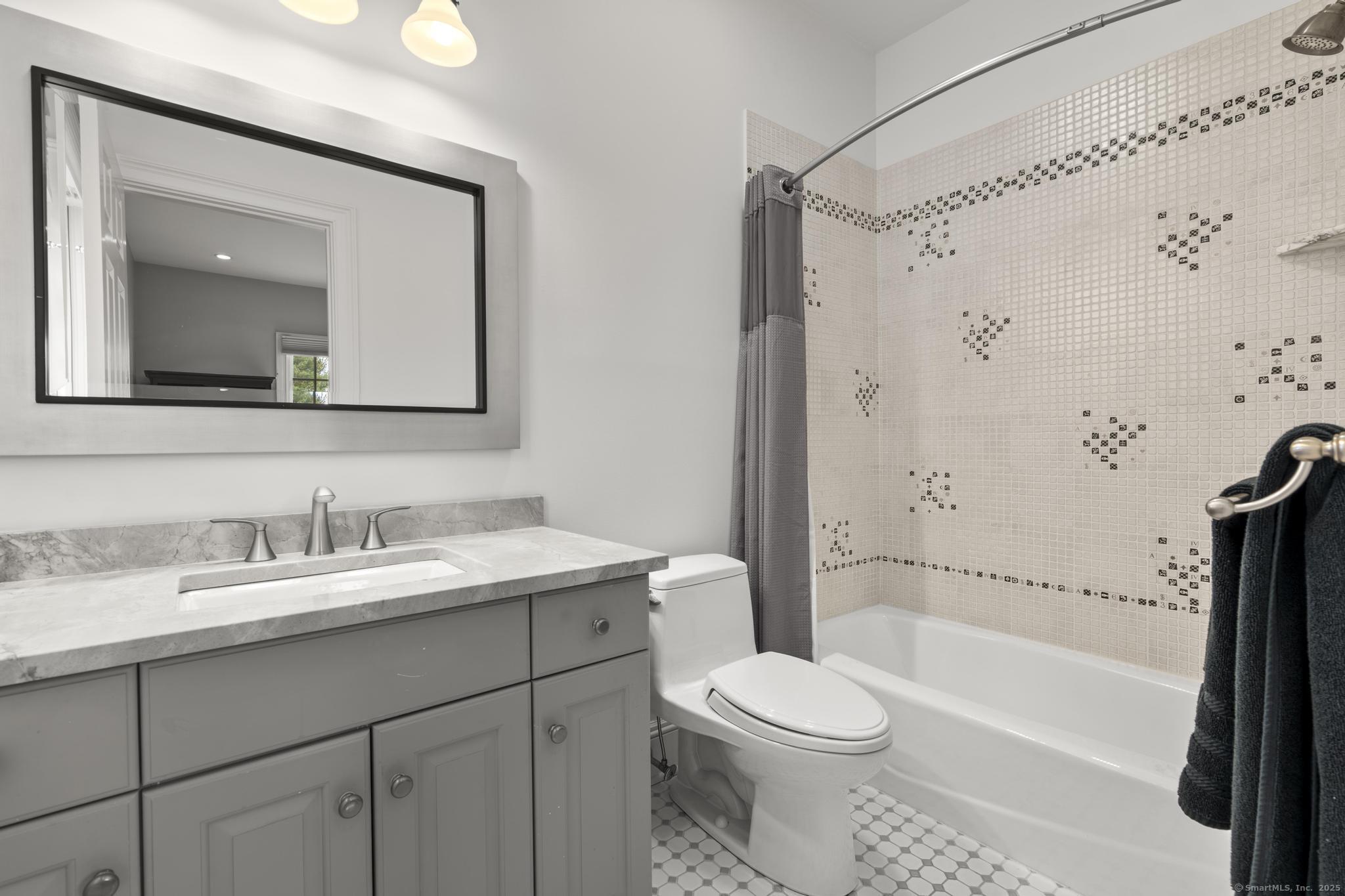 342 Midlock Road Fairfield, CT 06824 - Photo 29 of 40 a bathroom with a toilet a sink a bath tub and mirror