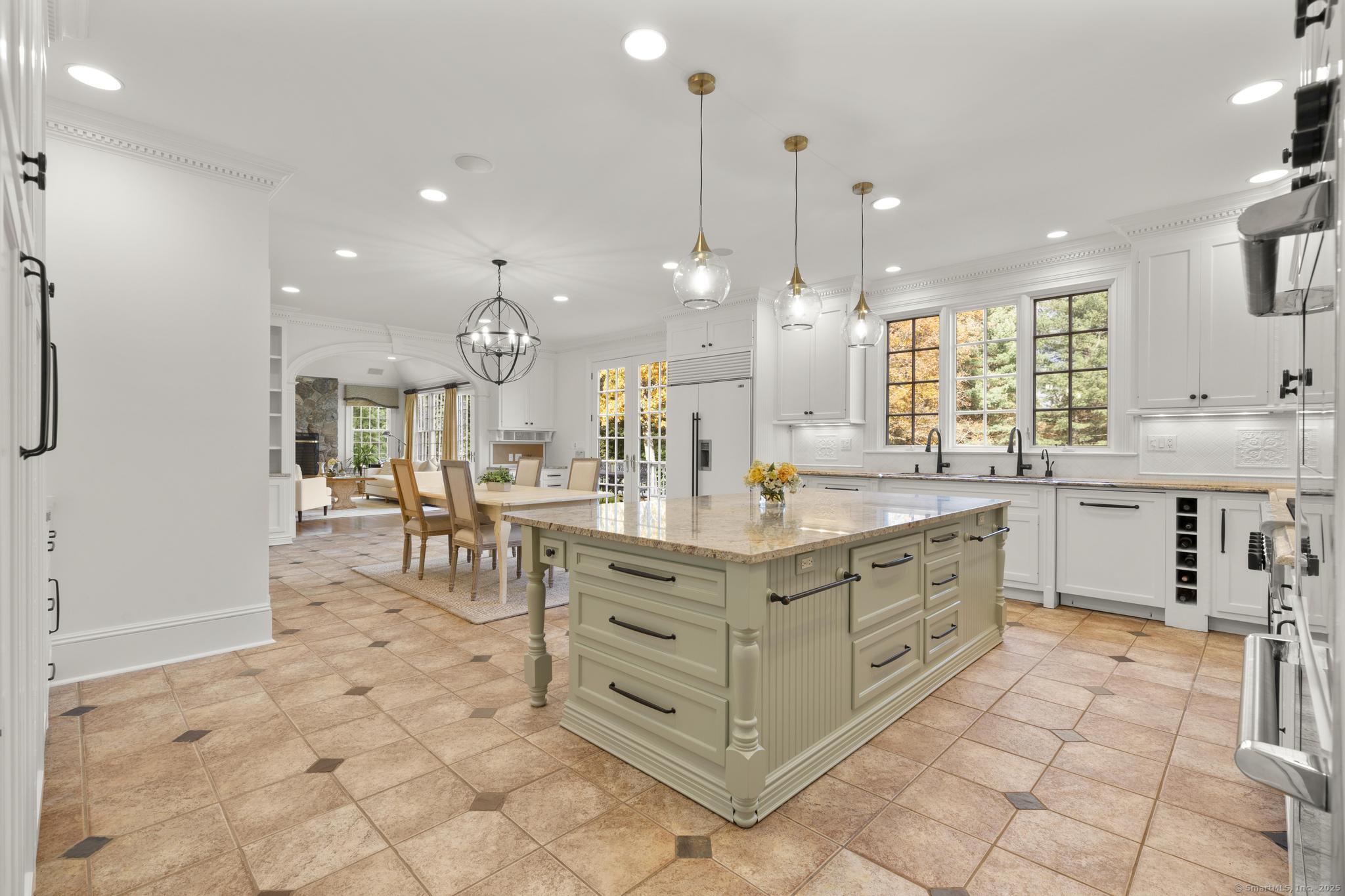 342 Midlock Road Fairfield, CT 06824 - Photo 10 of 40 a open kitchen with kitchen island granite countertop a stove a sink a dining table and chairs with the view