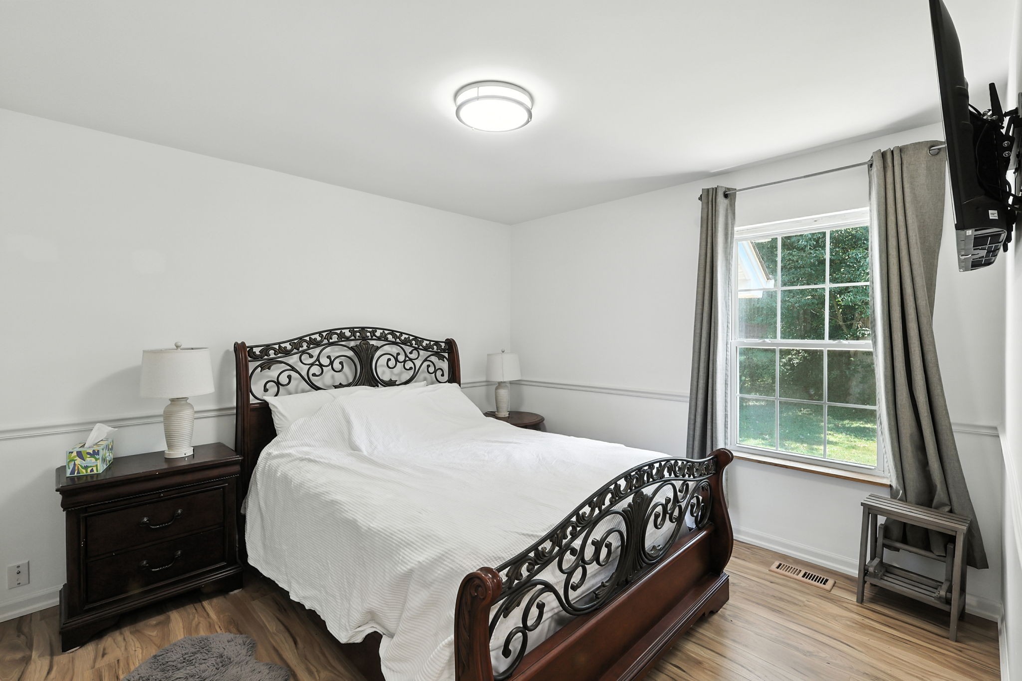 1121 Jacksons Valley Road Hermitage, TN 37076 - Photo 25 of 38 a bedroom with a bed and a flat tv screen on the dresser