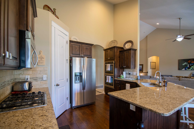 646 East 1400th Street North Mapleton, UT 84664 - Photo 19 of 78 Kitchen featuring granite countertops, dark wood cabinetry, stainless steel appliances, and wood-finish flooring