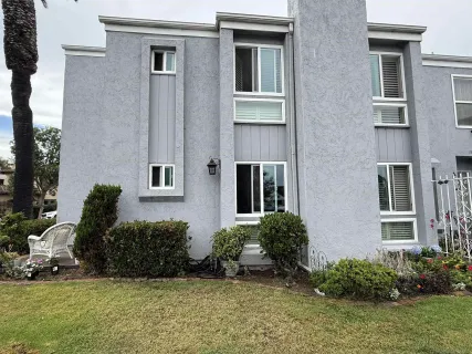 a view of a chair and table in backyard of the house